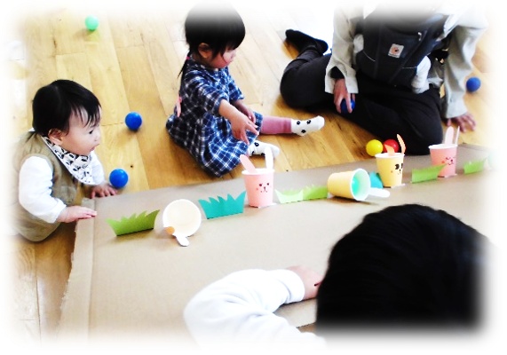 紙コップのおもちゃで遊んでいる園児たちの写真