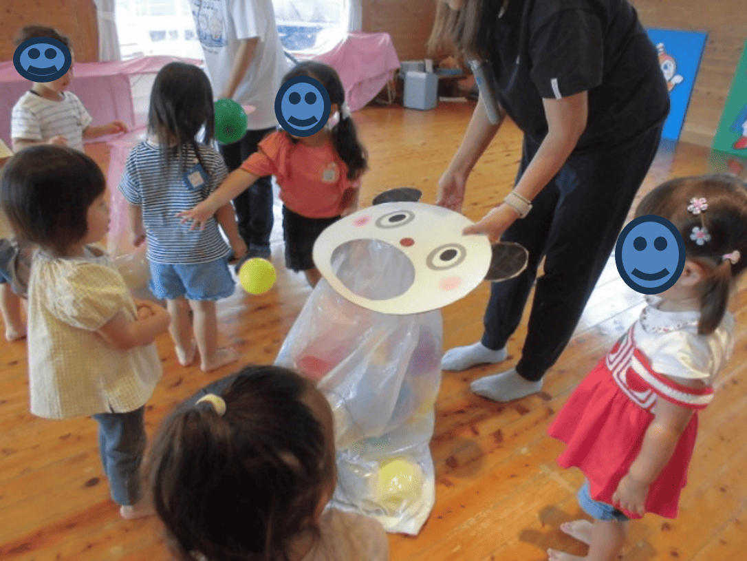 風船を玉入れにいれる子供たちの写真