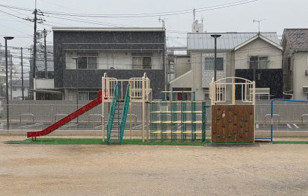 園庭の遊具に降る雨