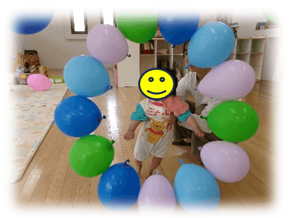 風船のリングをくぐる園児の写真