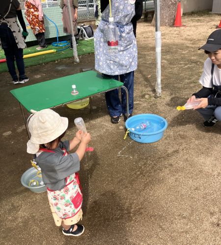 ペットボトルシャワーで遊ぶ子ども