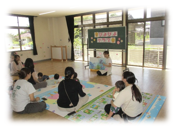 絵本の読み聞かせを聞く園児と保護者