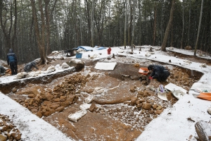雪の降る中、島状遺構の埴輪の検出作業をしている様子