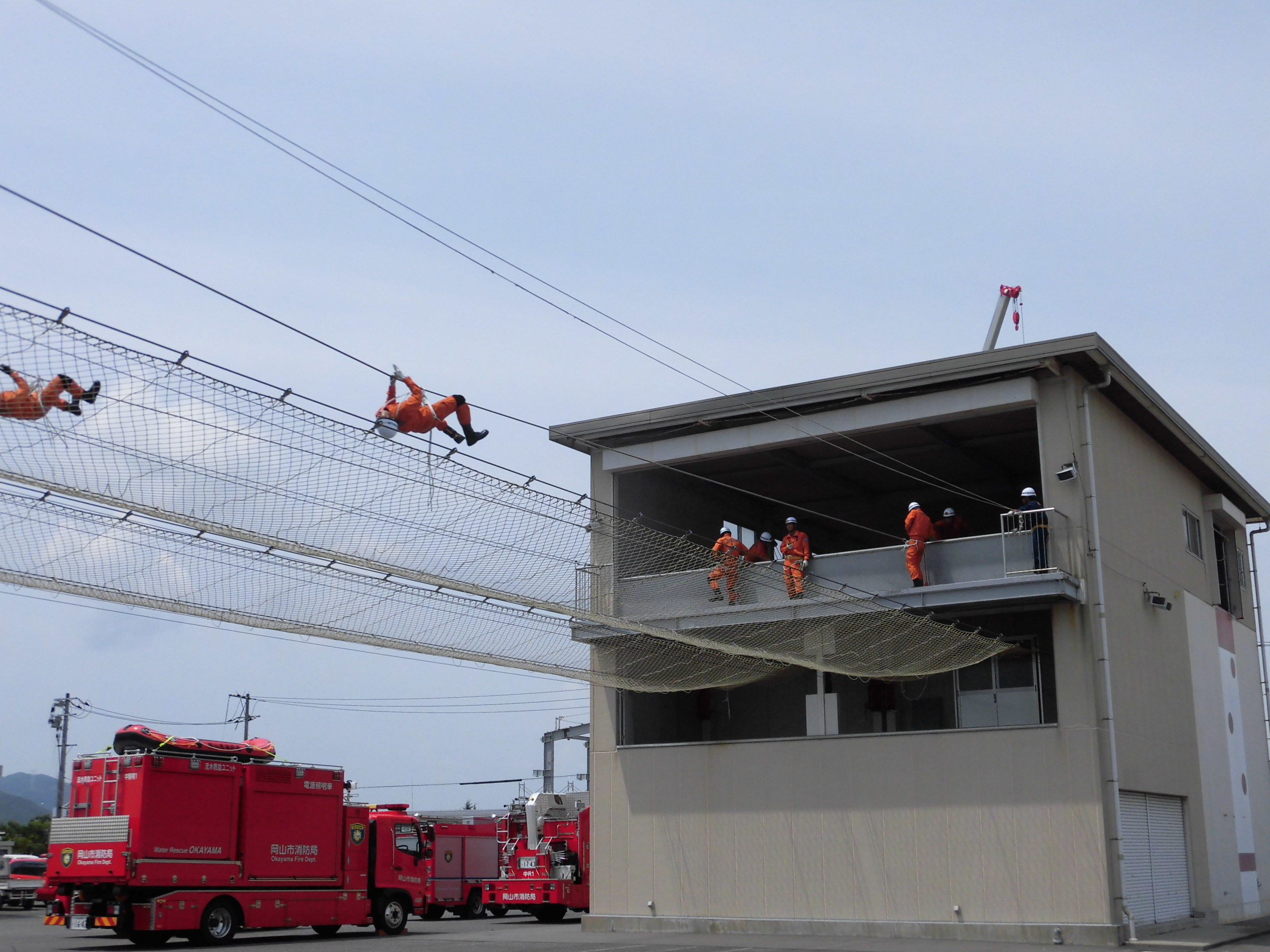 ロープブリッジ救出訓練で隊員がロープを渡っています