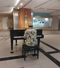 ストリートピアノを弾く男性