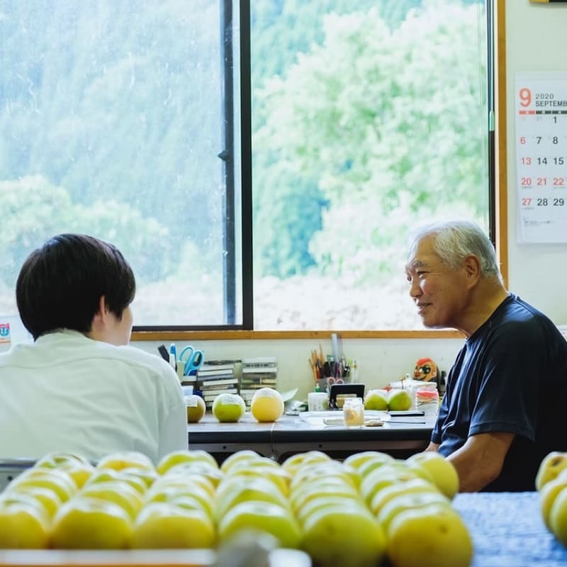 川村氏と年配の男性が話している写真