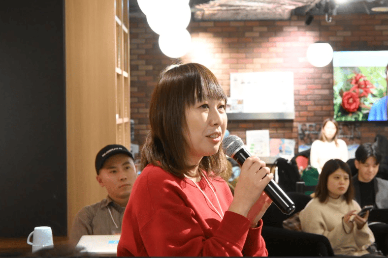 マイクを持ってしゃべっている女性参加者の写真