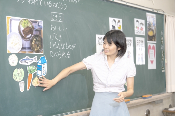 黒板の前にいる先生の写真