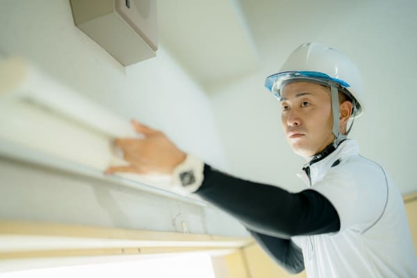 ヘルメットをかぶっている用務員の写真