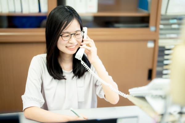 電話対応をする学校事務の写真